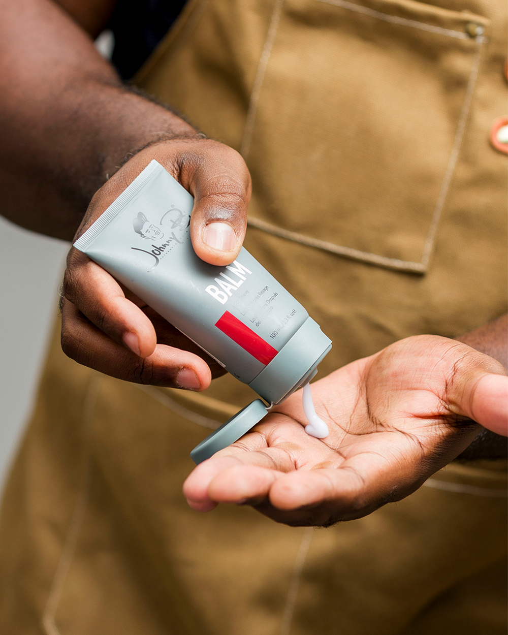 Barber squeezing Balm into hand