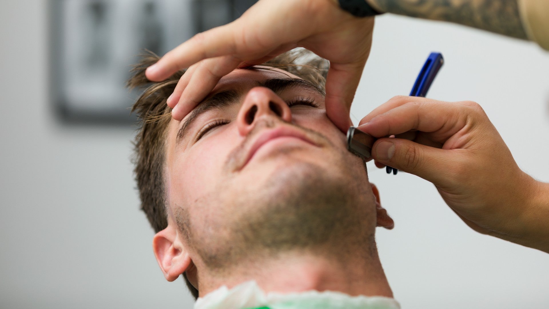 Barber shaving client's facial hair
