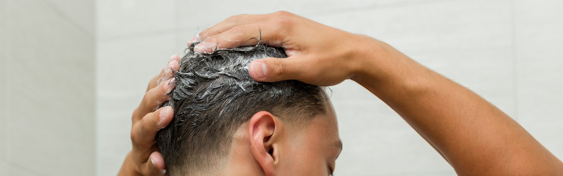 Man cleansing hair in shower