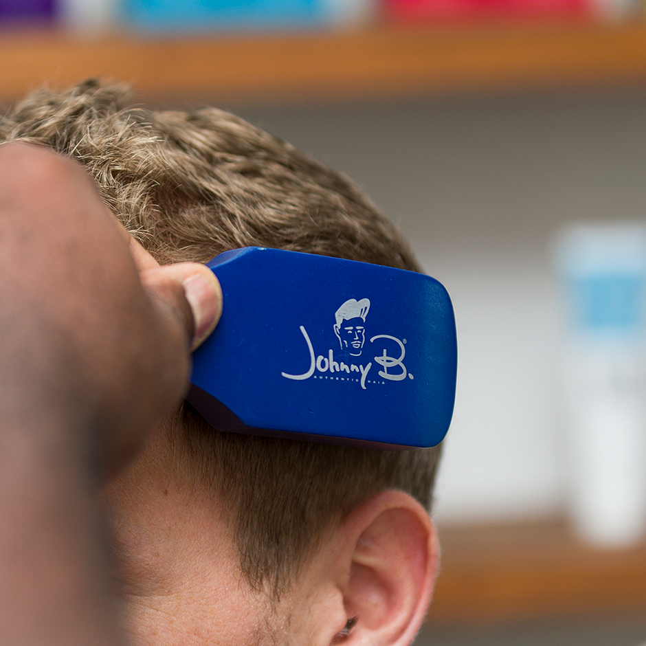 Barber cutting client's hair with Barber Brush