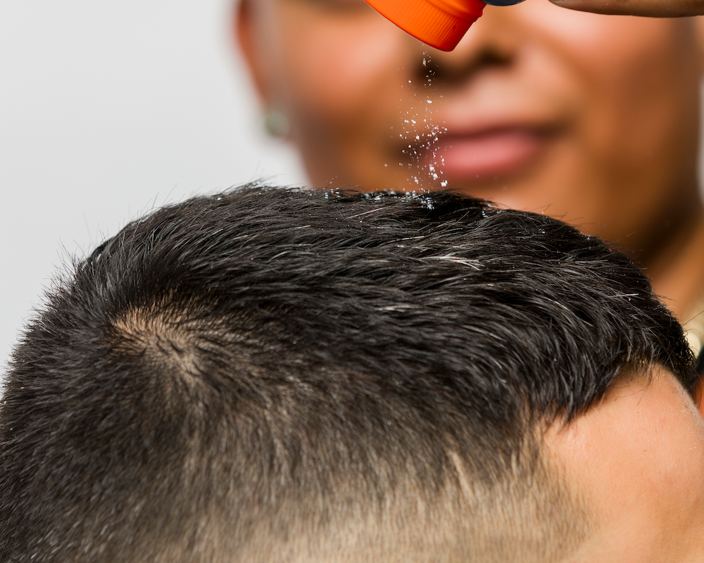 Barber applying Hold Up to client's hair