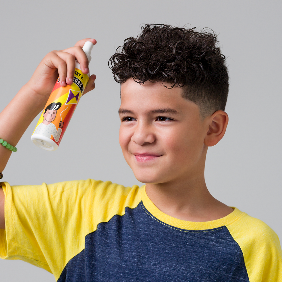 Child spraying Juniors Detangler into hair