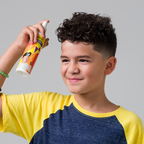 Child spraying Juniors Detangler into hair