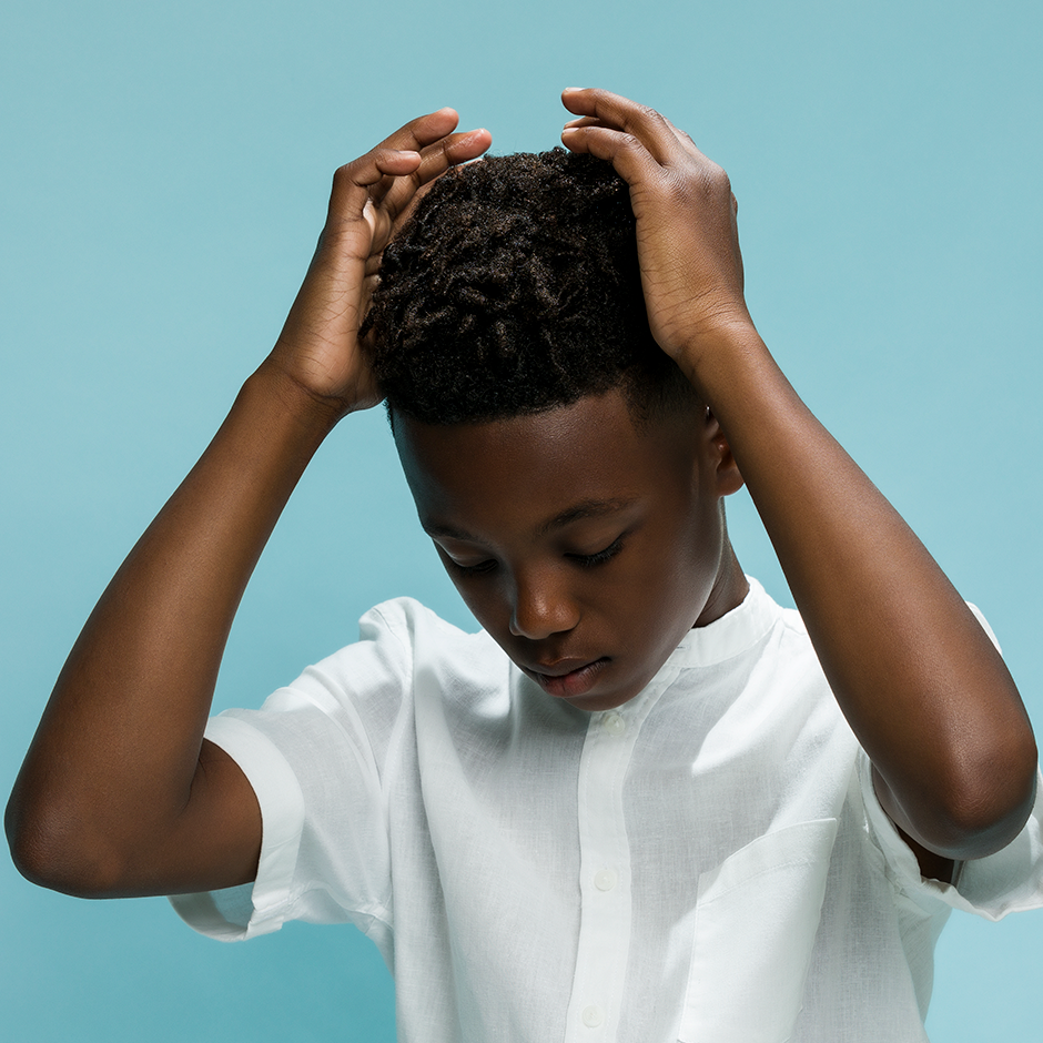 Child fixing hair and applying styling product