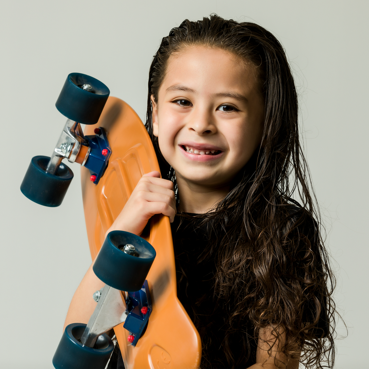 Kid holding up a skateboard