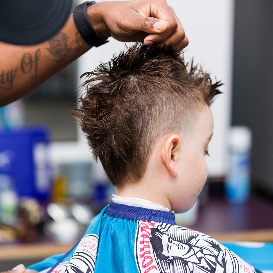 Barber styling child's hair with Juniors Pomade