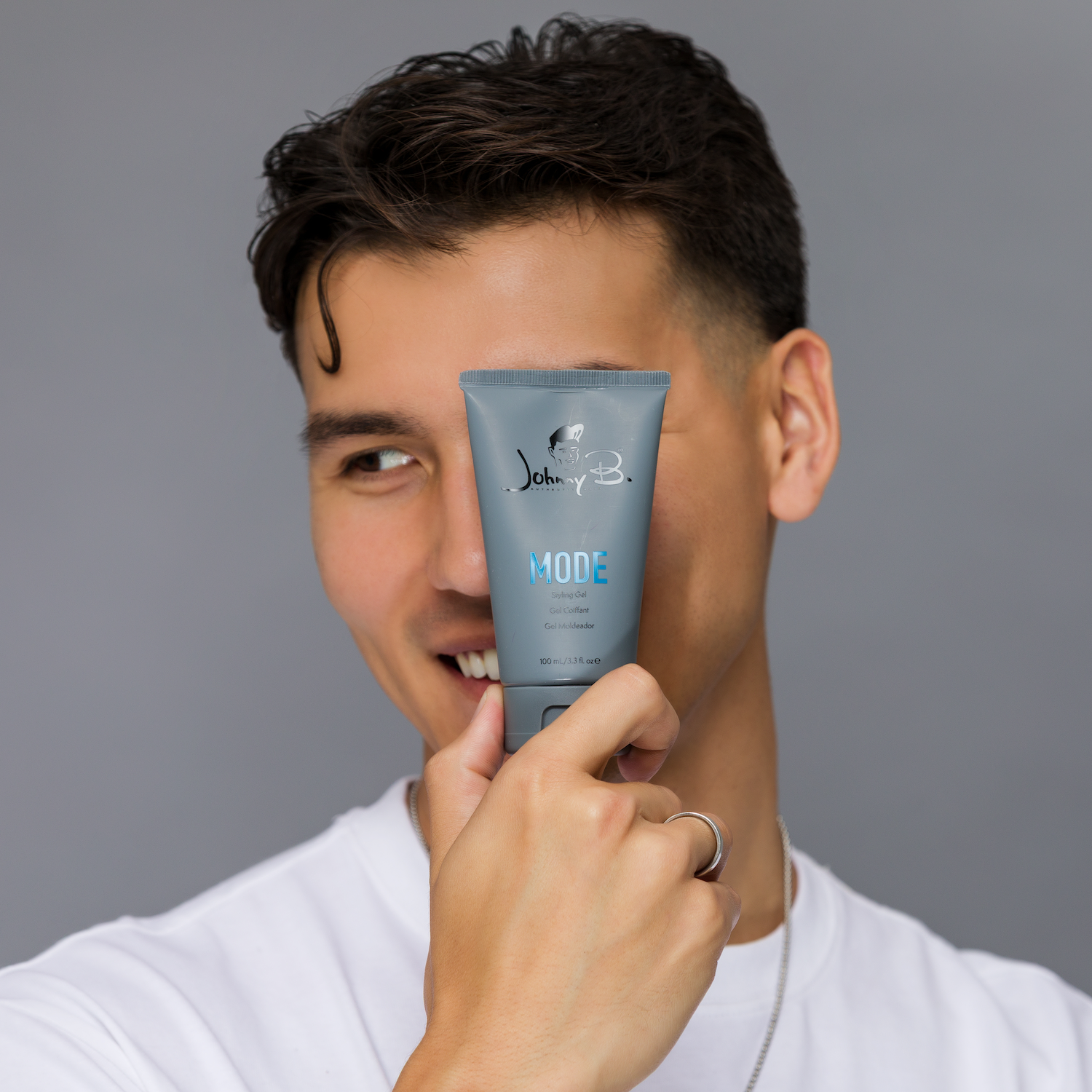 Man holding a tube of Mode against his face