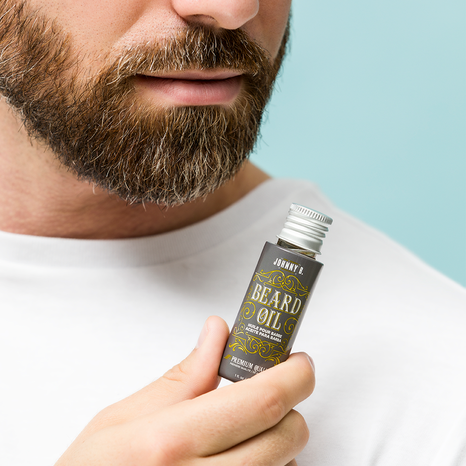 Man with thick beard holding Beard Oil