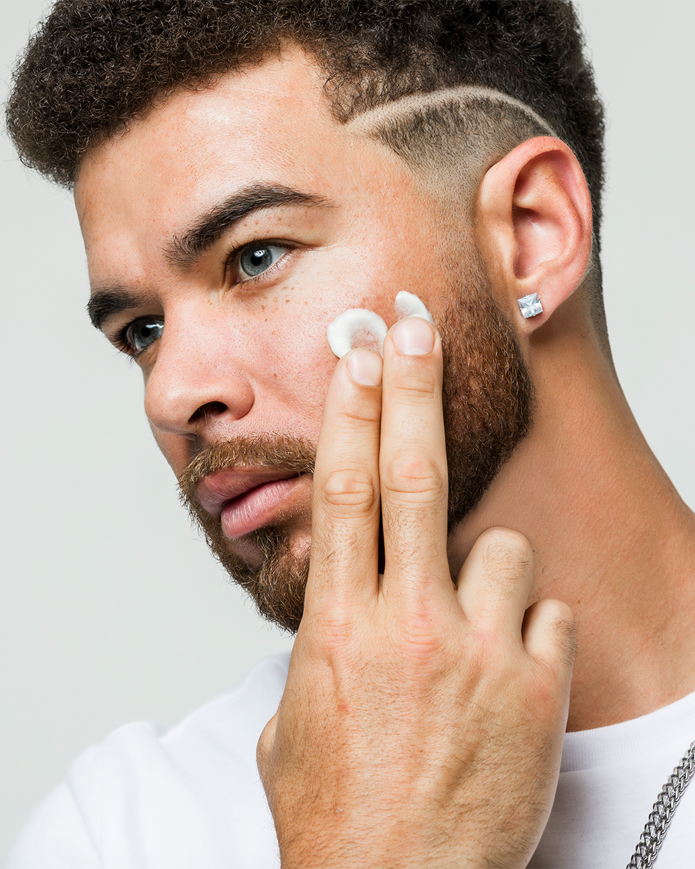 Man applying Body Balm on face