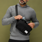 Man pulling out a tube of Utility Cream out of Move Easy crossbody bag