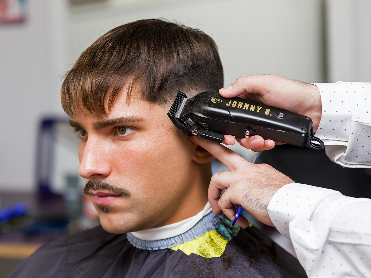 Barber trimming client's hair with Odyssey Clipper