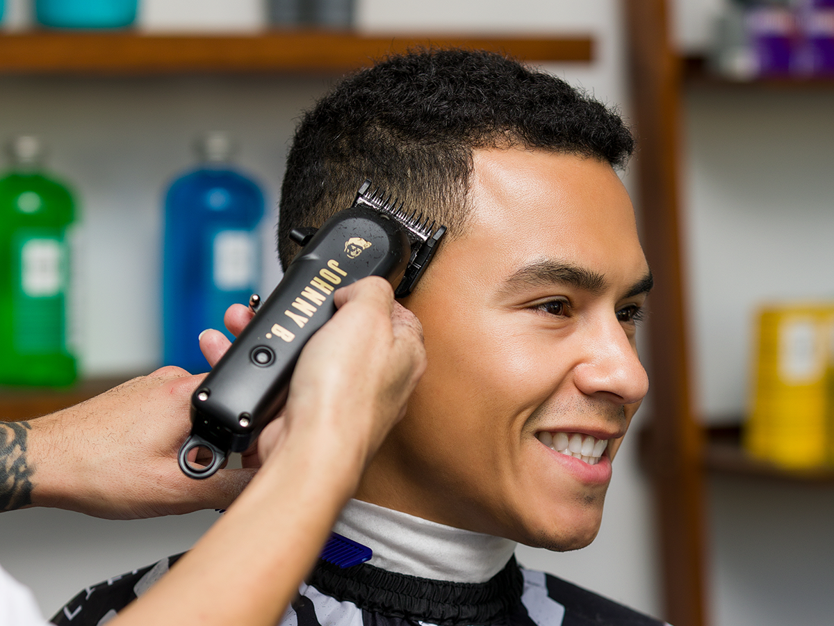 Barber trimming client's hair with Odyssey Clipper