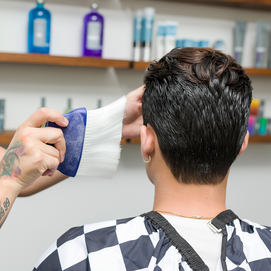 Barber dusting off client with Neck Duster