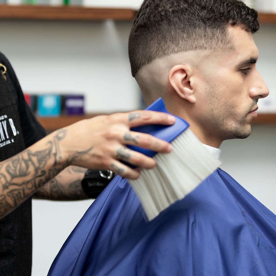Barber dusting off client with Neck Duster