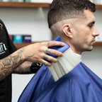 Barber dusting off client with Neck Duster