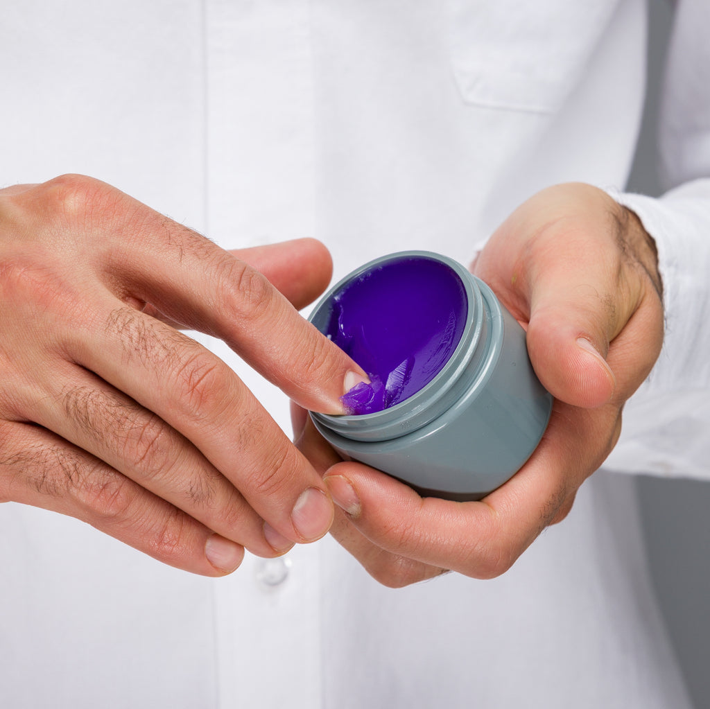 Man scooping some Original Pomade into hand