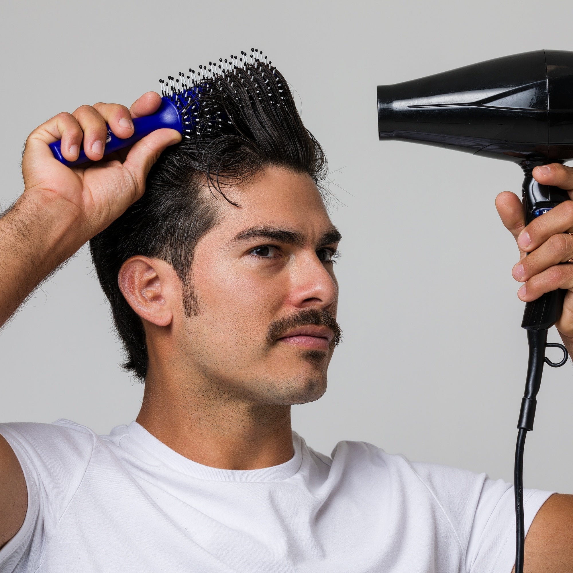Man styling his hair with Vent Brush and hair dryer