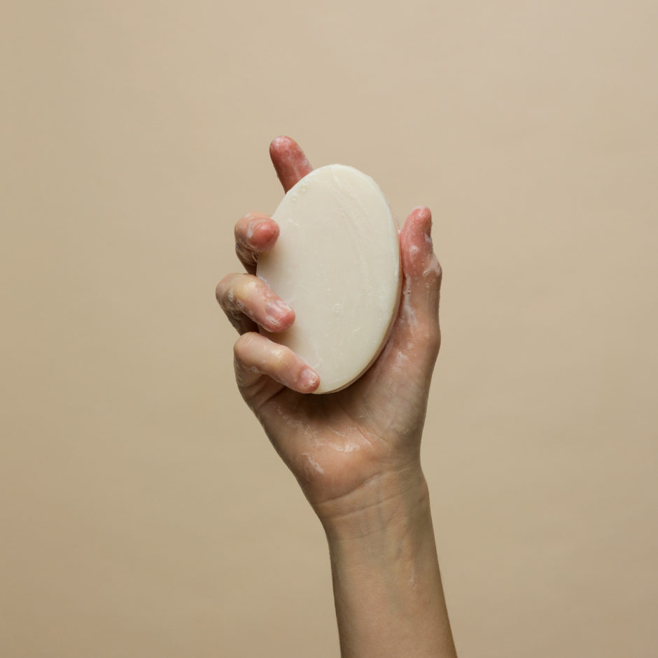 Model holding up lathered Ultra Soap Bar